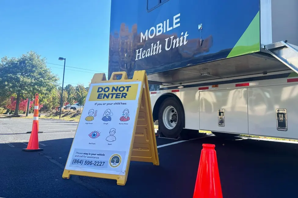 یک ون بهداشتی متحرک با تابلو A‑فریم زرد رنگ در جلوی خودرو که نوشته «ورود ممنوع»