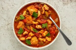 نمای بالای یک کاسه از خورشت میگو و ماهی